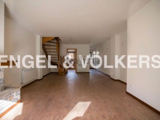 Spacious open-plan living area with wooden flooring and a stunning spiral staircase.