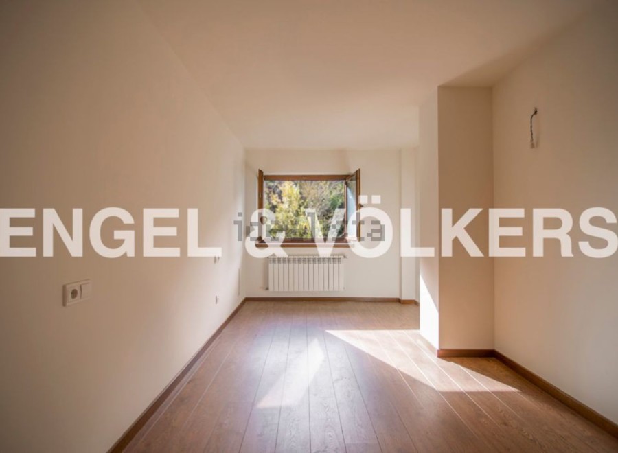 Bright and airy room with hardwood floors and large window offering ample natural light.