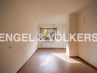 Bright and airy room with hardwood floors and large window offering ample natural light.