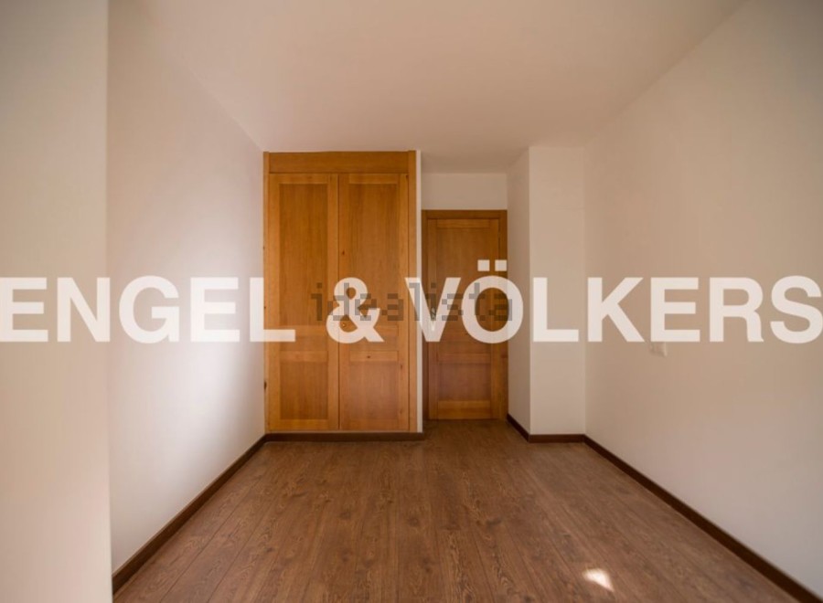 This bright and airy bedroom boasts ample closet space with built-in wooden wardrobes and offers plenty of natural light.