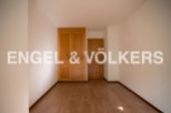 This bright and airy bedroom boasts ample closet space with built-in wooden wardrobes and offers plenty of natural light.