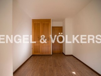 This bright and airy bedroom boasts ample closet space with built-in wooden wardrobes and offers plenty of natural light.