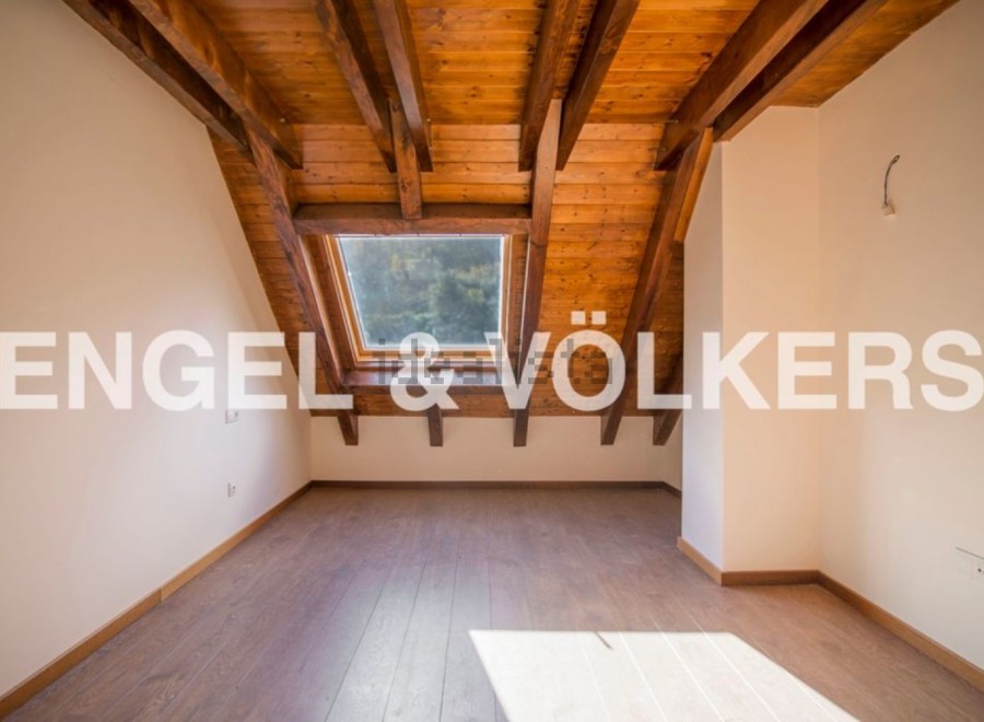 Discover this stunning attic room boasting a charming wooden ceiling and a large skylight that floods the space with natural light.