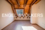 Discover this stunning attic room boasting a charming wooden ceiling and a large skylight that floods the space with natural light.
