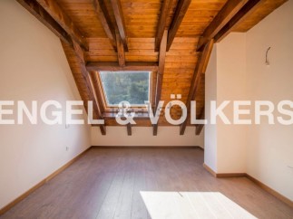 Discover this stunning attic room boasting a charming wooden ceiling and a large skylight that floods the space with natural light.