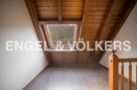 Discover this charming attic room boasting a stunning wooden ceiling and a large skylight that floods the space with natural light.
