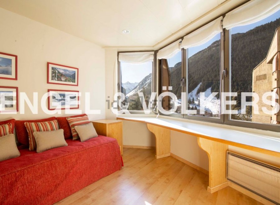 Mountain view apartment with a cozy red couch and built-in window seat.