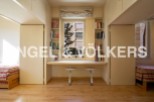 Bright apartment with built-in bookshelves and a study area.