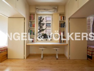 Bright apartment with built-in bookshelves and a study area.