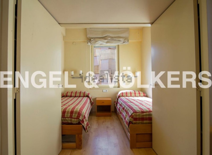 Cozy twin bedroom with built-in closets and a window offering natural light.