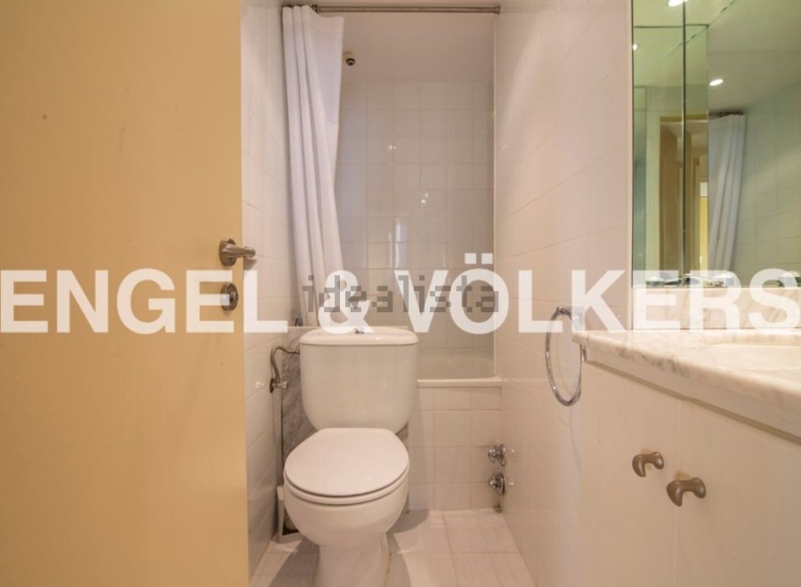 This stunning bathroom boasts a modern design with sleek white fixtures and a bathtub.