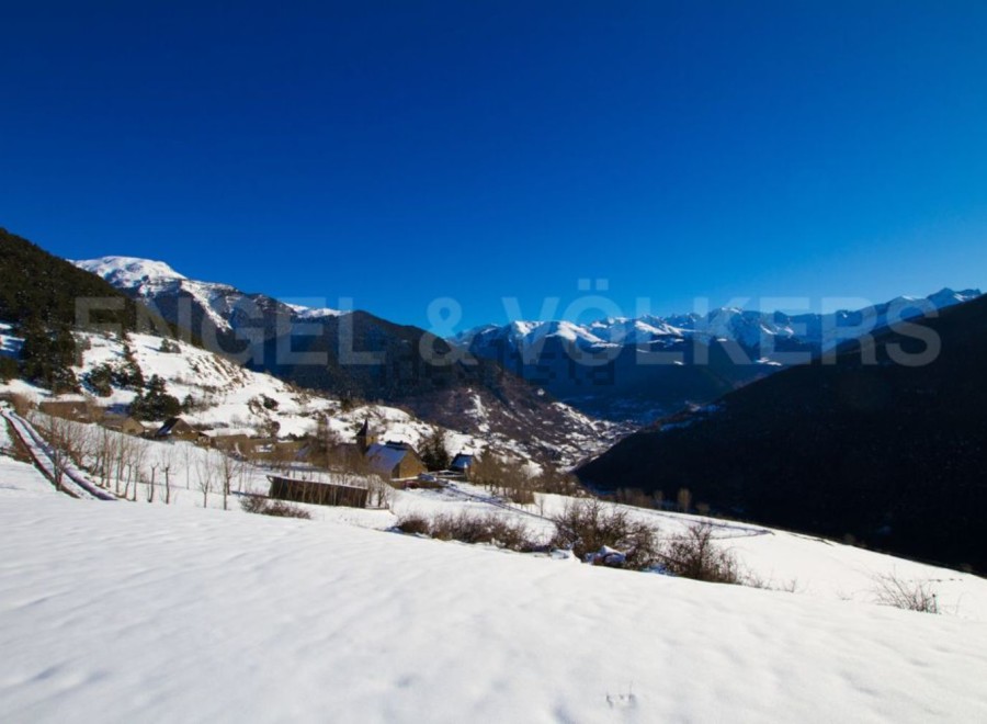 Mountain view home nestled in snowy valley.