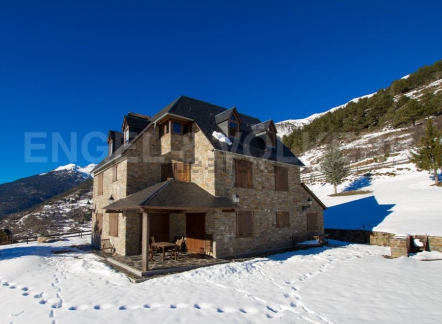 Discover a stunning stone house nestled in a picturesque snowy landscape.