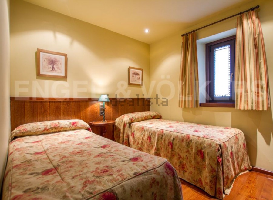 This cozy bedroom features two twin beds with floral bedding, perfect for guests.