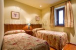 This cozy bedroom features two twin beds with floral bedding, perfect for guests.