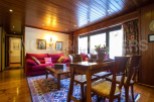 Discover the charm of this inviting living space, featuring a cozy red sofa and a stylish wooden dining set.