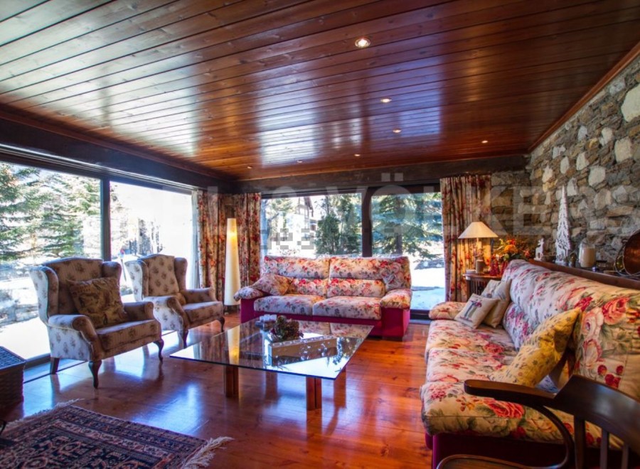 Experience the charm of this stunning living room, featuring a cozy ambiance with a wooden ceiling and floors.