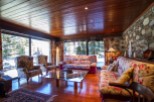 Experience the charm of this stunning living room, featuring a cozy ambiance with a wooden ceiling and floors.