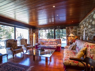 Experience the charm of this stunning living room, featuring a cozy ambiance with a wooden ceiling and floors.