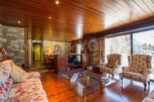 Discover the charm of this stunning property, featuring a cozy living room with a wooden ceiling and floors.