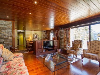 Discover the charm of this stunning property, featuring a cozy living room with a wooden ceiling and floors.