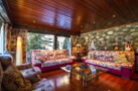 Step into a cozy living room with a stunning stone wall and a warm wooden ceiling.
