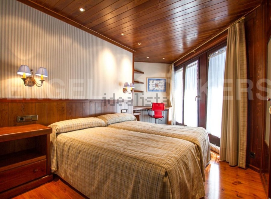 Discover a cozy bedroom with a warm wooden ceiling and flooring.