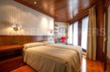 Discover a cozy bedroom with a warm wooden ceiling and flooring.