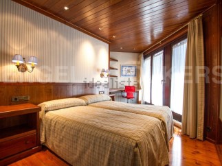 Discover a cozy bedroom with a warm wooden ceiling and flooring.