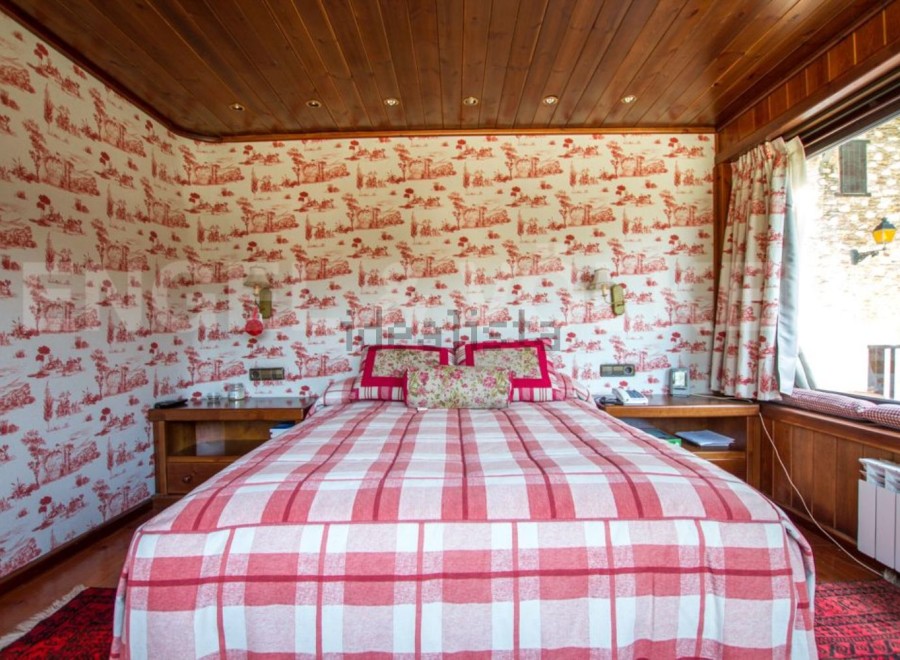 Cozy bedroom with a charming red and white plaid bedspread.