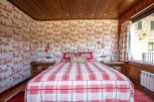 Cozy bedroom with a charming red and white plaid bedspread.