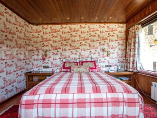 Cozy bedroom with a charming red and white plaid bedspread.