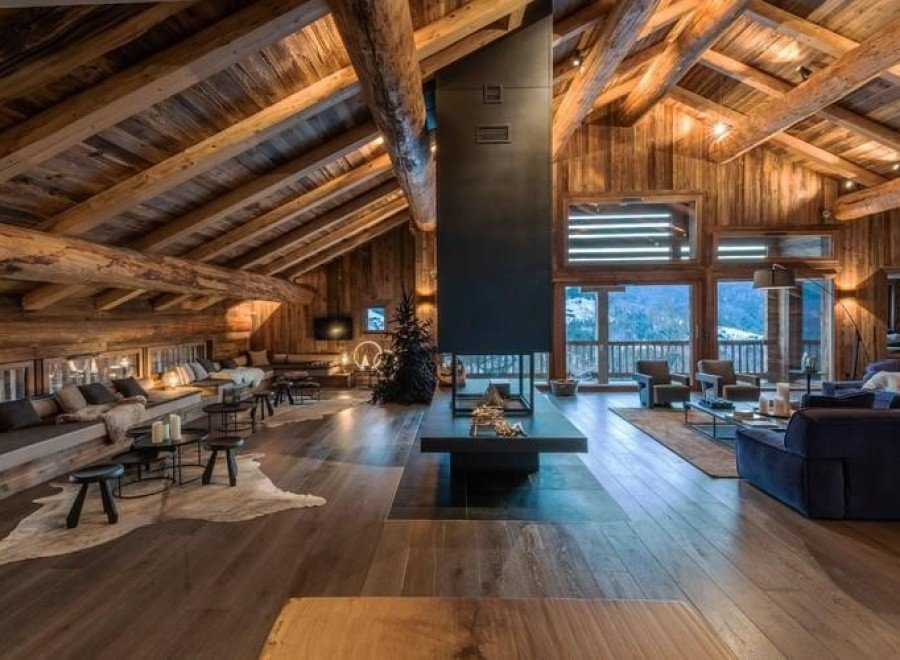 Luxury chalet with stunning mountain views and a large, open-plan living area featuring a dramatic fireplace.