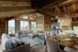 This stunning chalet boasts a spacious open-plan living area with floor-to-ceiling windows offering breathtaking mountain views.