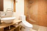 This modern bathroom features a sleek design with a vessel sink and a wooden vanity.
