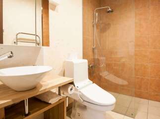 This modern bathroom features a sleek design with a vessel sink and a wooden vanity.