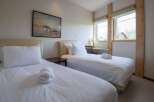 This cozy bedroom features two twin beds, perfect for guests or roommates.