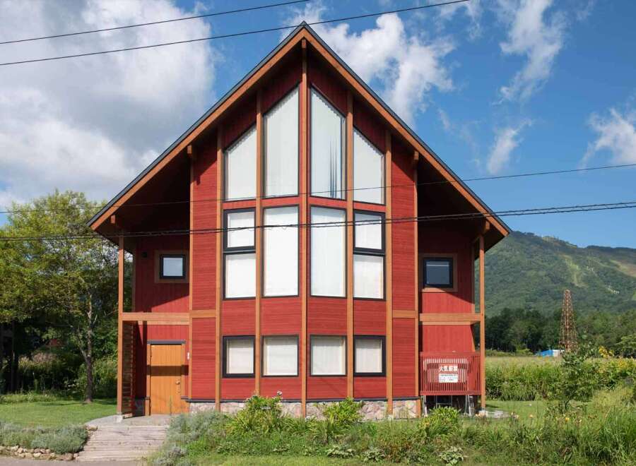 This stunning property boasts a modern design with a striking red exterior and a unique architectural style.