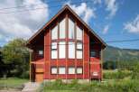 This stunning property boasts a modern design with a striking red exterior and a unique architectural style.