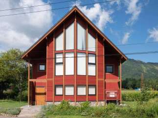 This stunning property boasts a modern design with a striking red exterior and a unique architectural style.