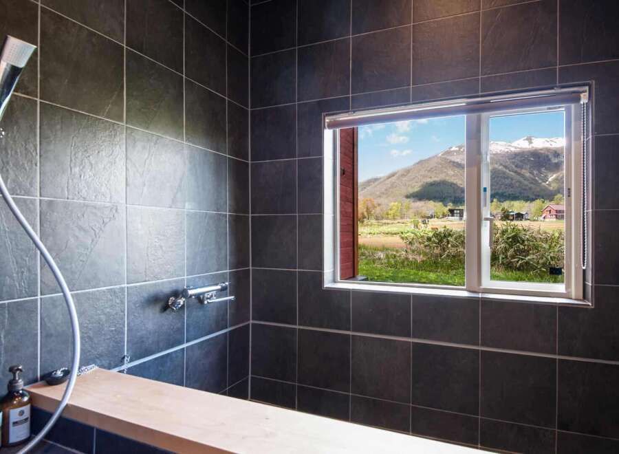 Experience tranquility in this stunning bathroom featuring a breathtaking mountain view.