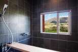 Experience tranquility in this stunning bathroom featuring a breathtaking mountain view.