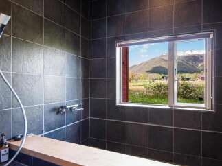 Experience tranquility in this stunning bathroom featuring a breathtaking mountain view.
