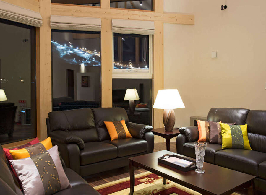 Experience luxury living in this stunning property, featuring a spacious living room with comfortable leather sofas and elegant decor.