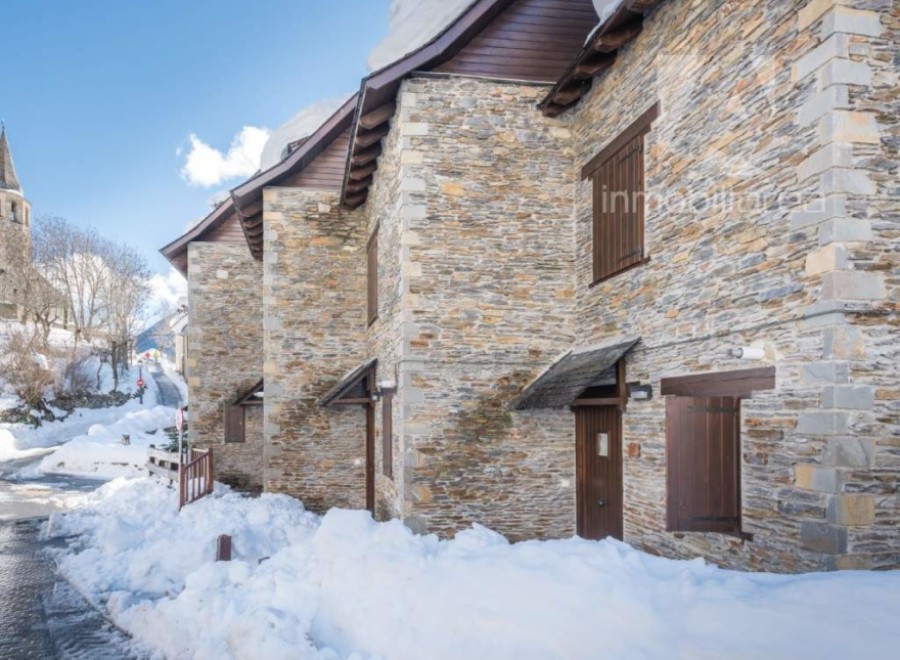 Discover charming stone houses nestled in a snowy village.