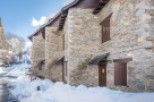 Discover charming stone houses nestled in a snowy village.