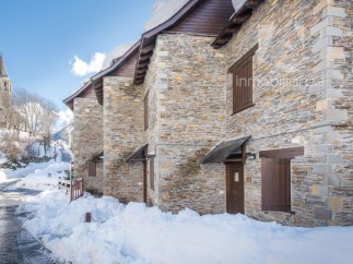 Discover charming stone houses nestled in a snowy village.