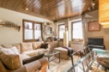 This charming living space boasts a cozy atmosphere with its wooden ceiling and inviting sofa.