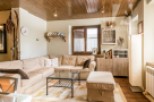 This cozy living room features a warm, inviting atmosphere with its wooden ceiling and comfortable seating.