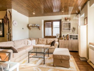 This cozy living room features a warm, inviting atmosphere with its wooden ceiling and comfortable seating.